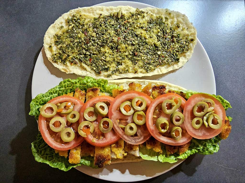 Panini mit Salat, Hähnchen, Pesto, Tomaten & Oliven