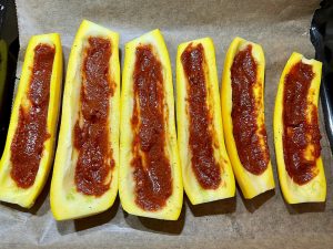Rote scharfe Paste auf Zucchini verteilen