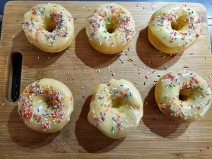 Donuts mit weißer Schokoglasur und bunten Streusel