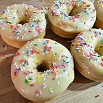 Donuts mit weißer Schokoglasur und bunten Streusel