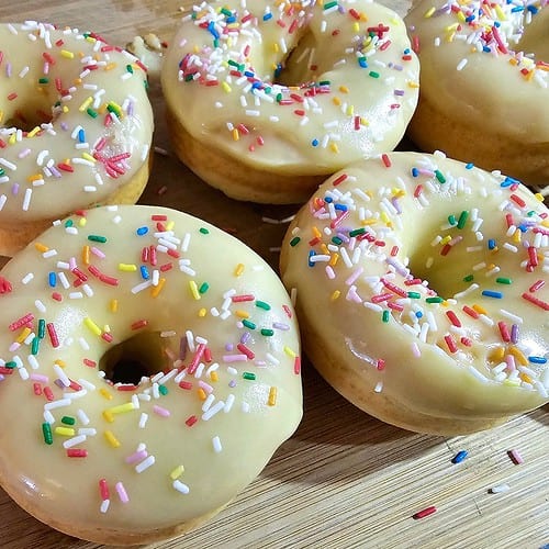 Donuts mit weißer Schokoglasur und bunten Streusel